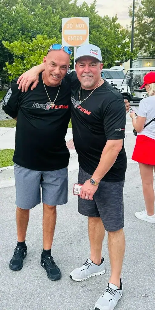 Mike Geraud and Damon Marotta Sr. arm in arm in Fuel 1 Team shirts at a race site