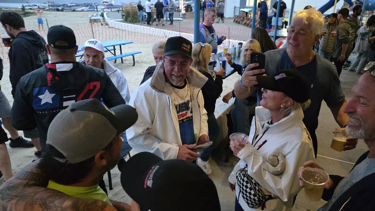 Fans crowd around racers in white jackets at the Lake Hopatcong waterfront
