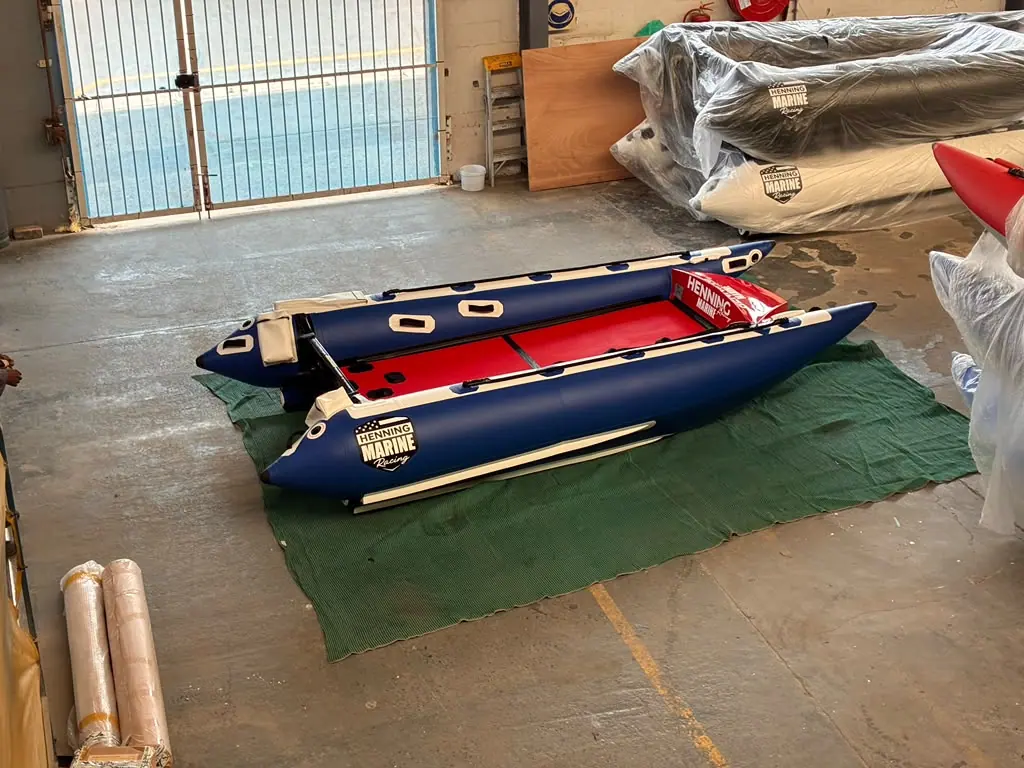 The Fuel 1 Team ThunderCat on the build-shop floor beside wrapped Henning Marine hulls