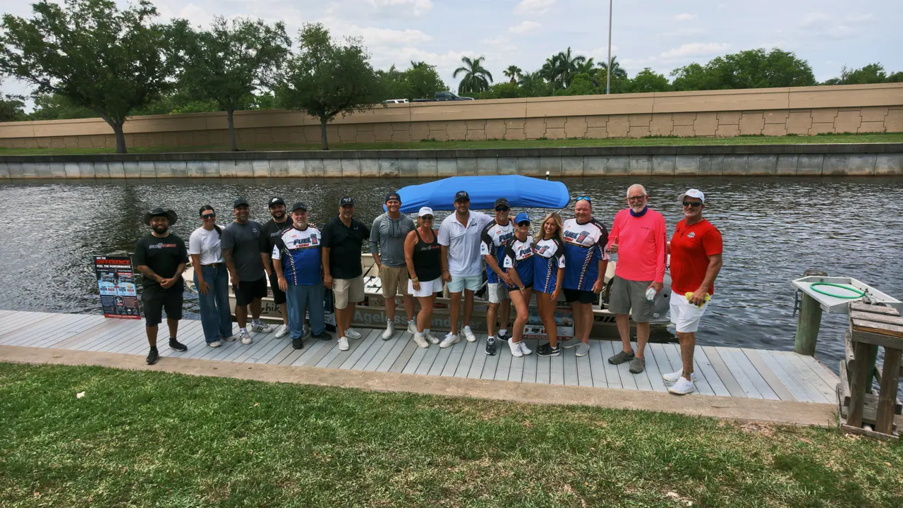 About fifteen Fuel 1 team members and partners lined up on a canal-side dock