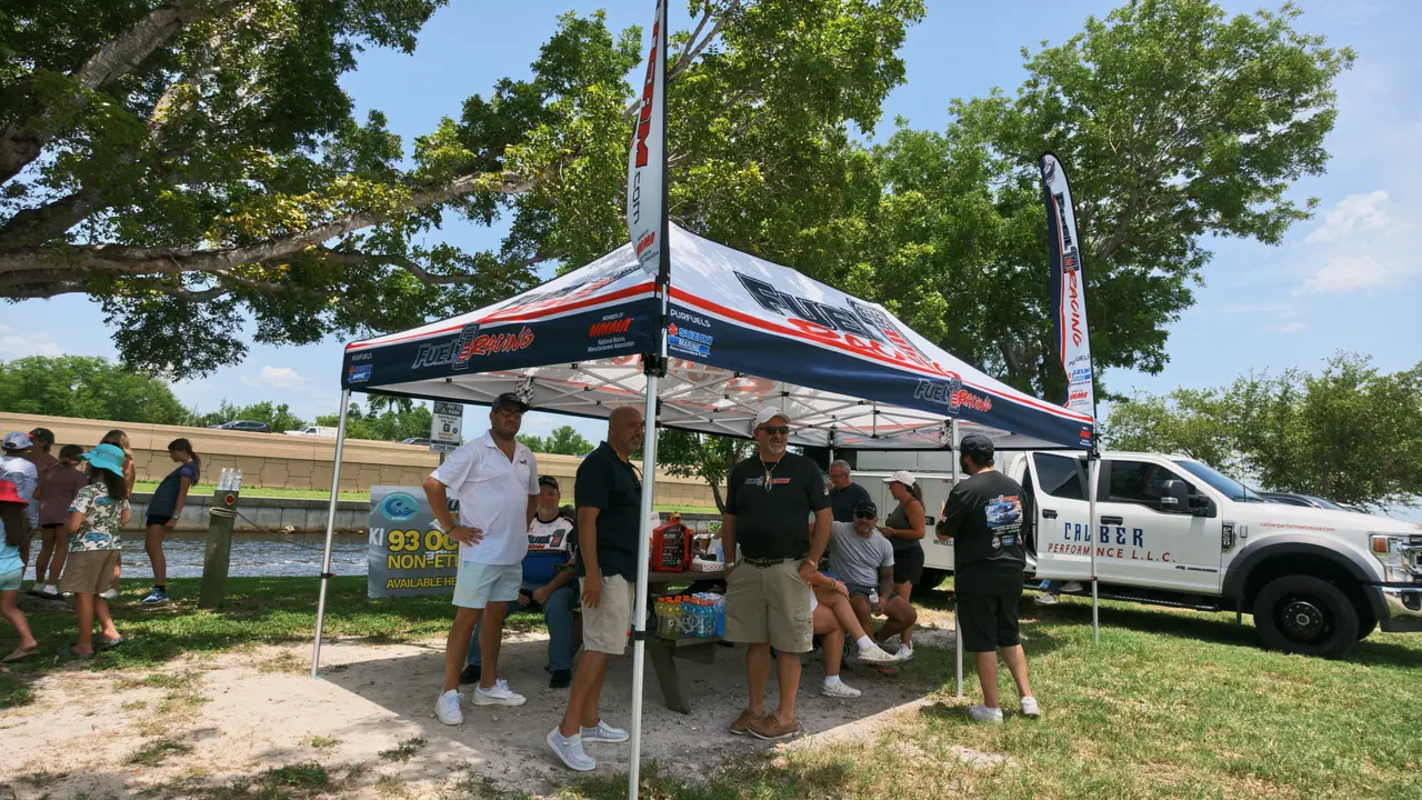 Fuel 1 team members under the Fuel 1 tent next to a trailer-mounted fuel station