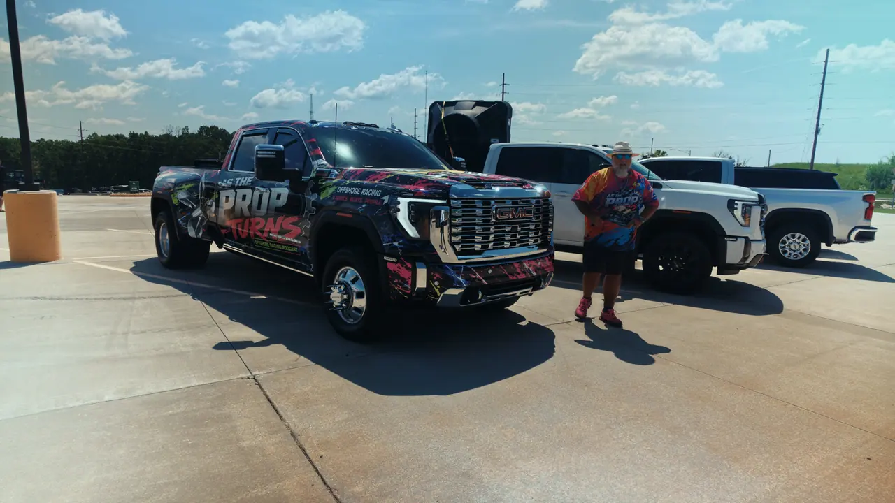 A Fuel 1 wrapped pickup and trailer parked in a race-site lot